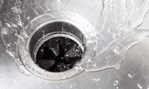water flowing down stainless steel kitchen sink drain