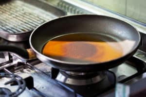 cast iron pan with cooking grease on gas stove