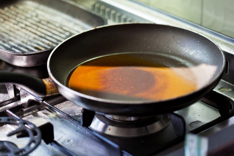  cast iron pan with cooking grease on gas stove 