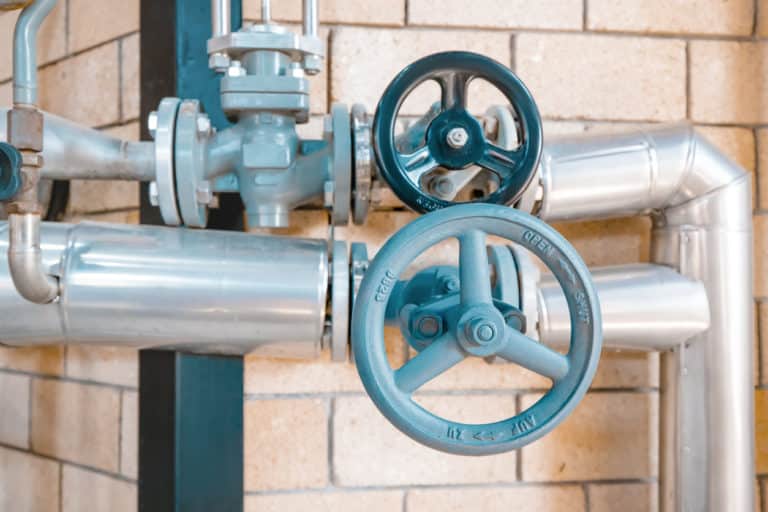 gas line pipes posing in front of brick wall